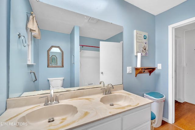 bathroom featuring vanity, wood-type flooring, and toilet