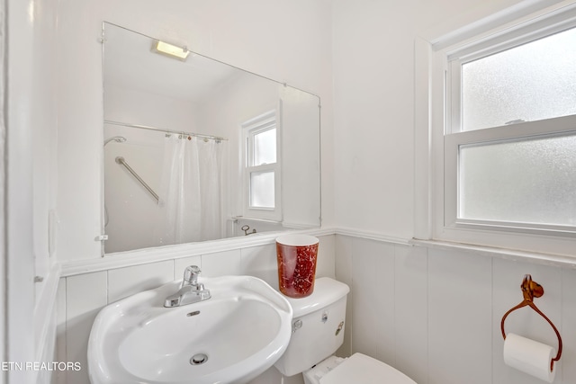 bathroom with toilet, a shower with curtain, and sink