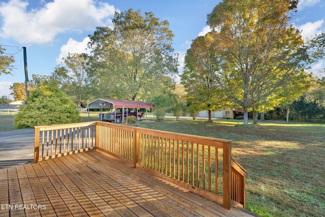 wooden deck featuring a yard and a carport