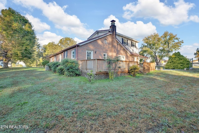 rear view of house with a wooden deck and a yard