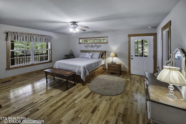 bedroom featuring a textured ceiling, ceiling fan, and wood-type flooring