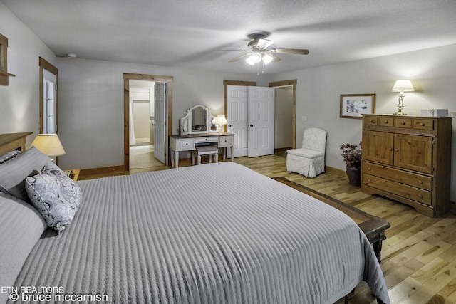 bedroom featuring ceiling fan, a textured ceiling, connected bathroom, and light hardwood / wood-style floors