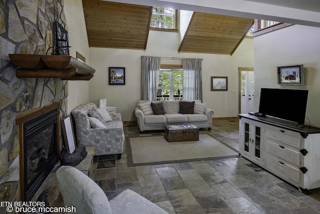 living room featuring wooden ceiling, a stone fireplace, and high vaulted ceiling