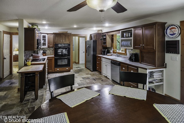 kitchen featuring black appliances, decorative backsplash, dark brown cabinets, and sink