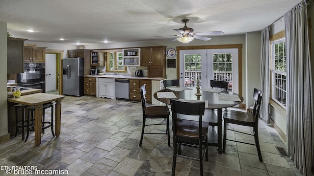 dining area featuring a textured ceiling, ceiling fan, french doors, and sink