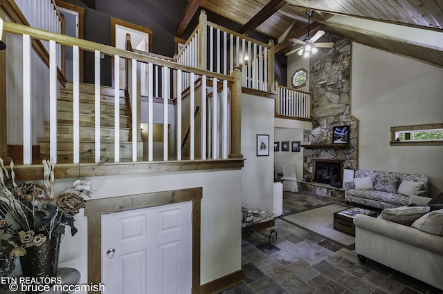 living room featuring ceiling fan, wooden ceiling, a fireplace, high vaulted ceiling, and beamed ceiling