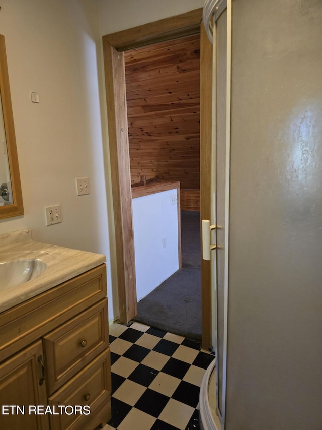 bathroom with vanity and wood walls