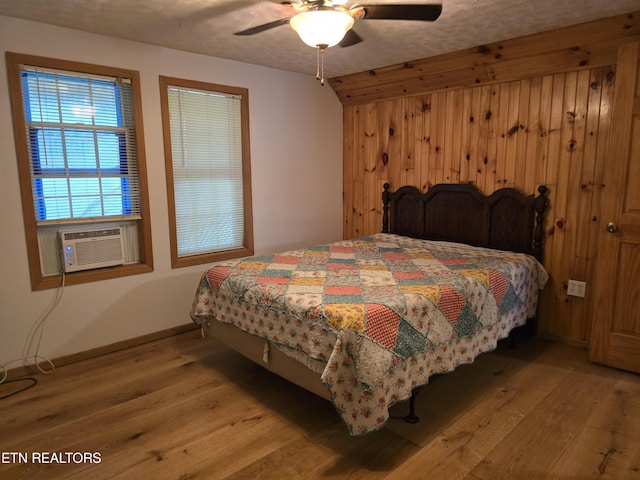 bedroom featuring a textured ceiling, light hardwood / wood-style flooring, ceiling fan, and cooling unit