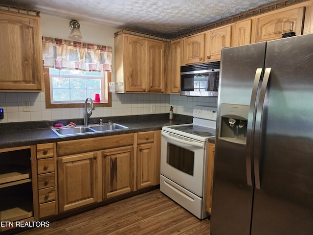 kitchen with tasteful backsplash, dark hardwood / wood-style flooring, sink, and appliances with stainless steel finishes