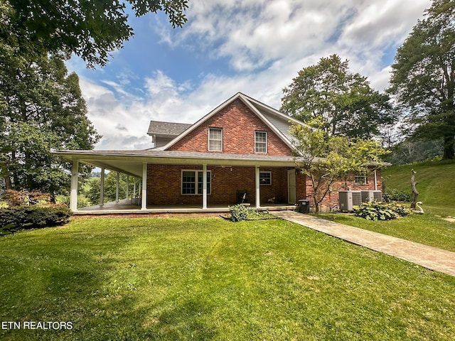 rear view of property featuring brick siding and a lawn