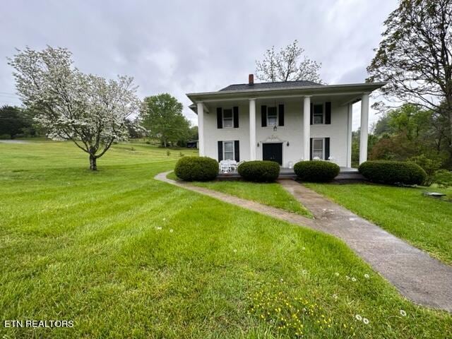 696 Forge Ridge Rd, Harrogate, TN 37752 - neoclassical / greek revival house featuring a front yard, covered porch, stucco siding, and a chimney