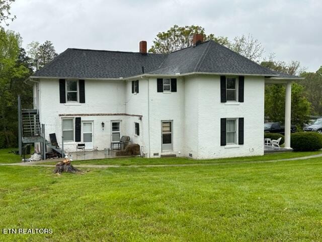 rear view of house featuring a yard