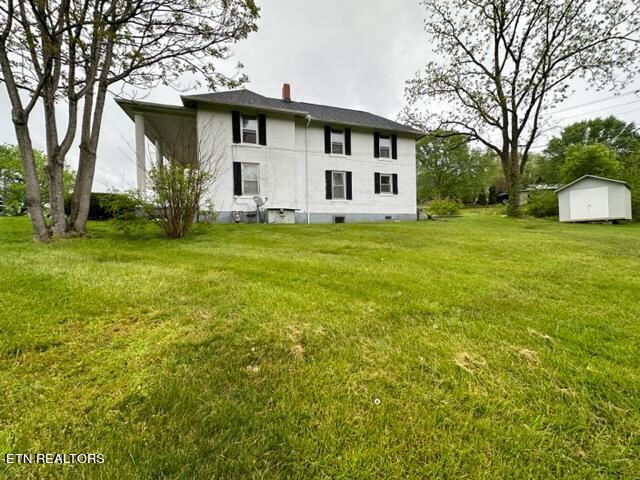 696 Forge Ridge Rd, Harrogate, TN 37752 - back of house featuring a storage unit, a yard, and a chimney