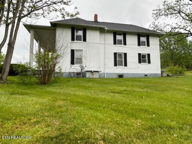 rear view of property featuring a yard