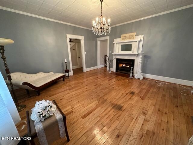 living room featuring a chandelier, hardwood / wood-style floors, and ornamental molding