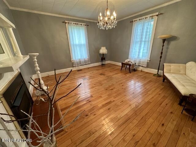 696 Forge Ridge Rd, Harrogate, TN 37752 - unfurnished room featuring hardwood / wood-style floors, ornamental molding, a chandelier, and a fireplace