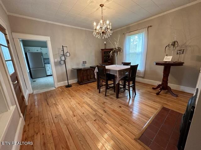 dining area featuring a notable chandelier, crown molding, and light hardwood / wood-style flooring