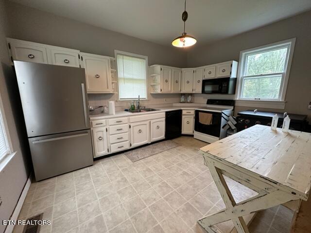 kitchen with tasteful backsplash, sink, black appliances, decorative light fixtures, and white cabinetry