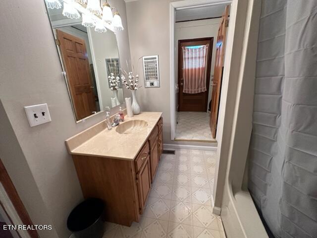 bathroom featuring vanity, walk in shower, and an inviting chandelier