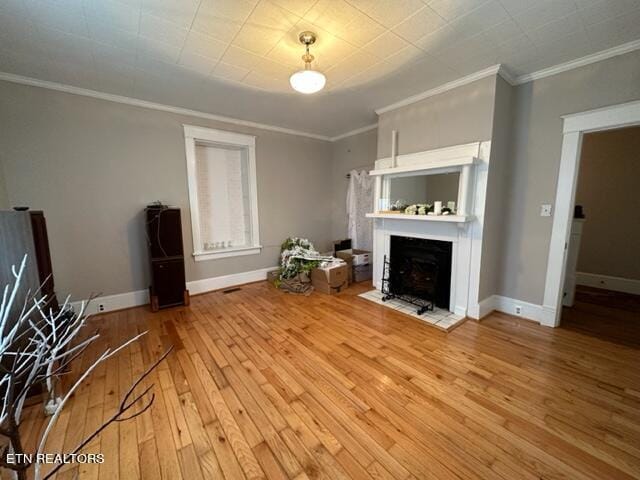 unfurnished living room featuring wood-type flooring and ornamental molding