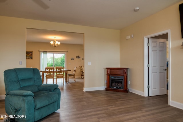 living room with dark wood-type flooring and a notable chandelier