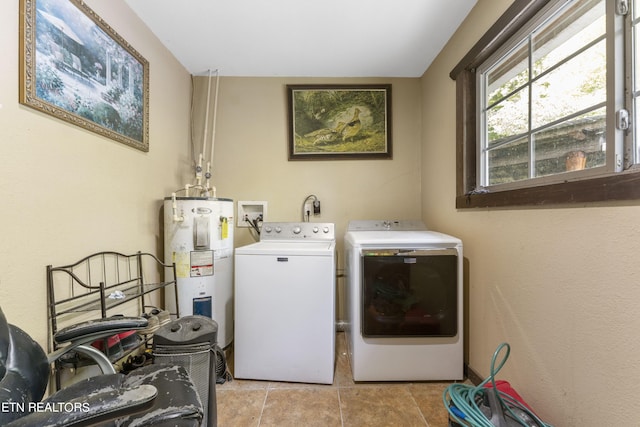 laundry room featuring washing machine and dryer, electric water heater, and light tile patterned floors