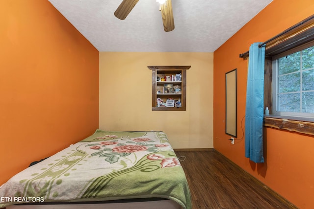 bedroom featuring ceiling fan, dark wood-type flooring, and a textured ceiling