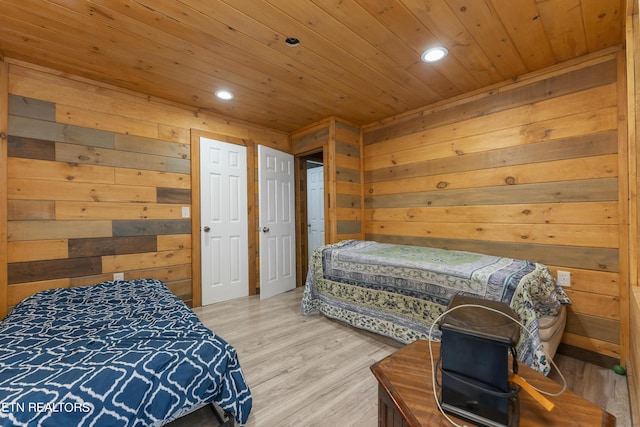 bedroom featuring light hardwood / wood-style floors, wooden walls, and wood ceiling