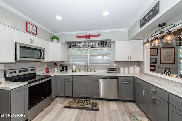 kitchen featuring gray cabinets, sink, white cabinetry, and stainless steel appliances