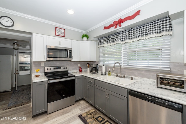 kitchen featuring gray cabinetry, sink, white cabinets, and appliances with stainless steel finishes