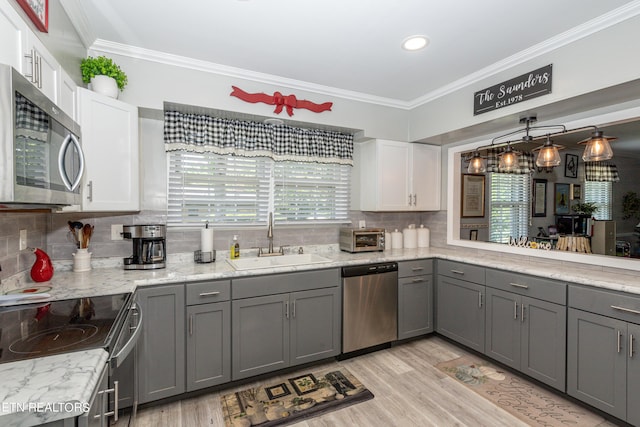 kitchen featuring white cabinets, gray cabinets, sink, and appliances with stainless steel finishes