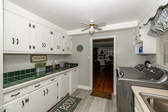 kitchen with separate washer and dryer, white cabinetry, and tile counters