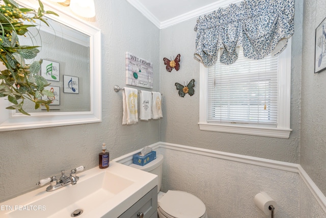 bathroom featuring vanity, toilet, and ornamental molding