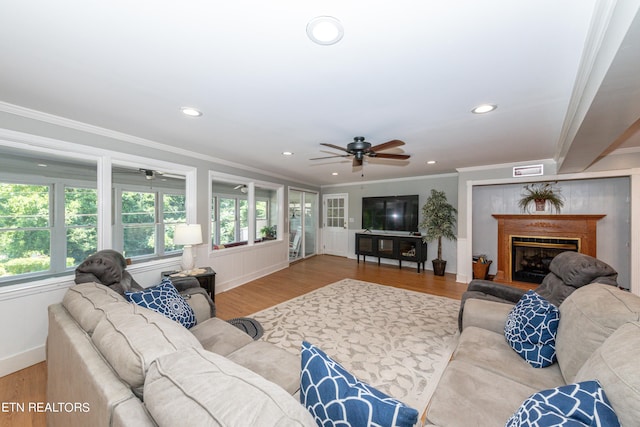 living room featuring hardwood / wood-style floors, ceiling fan, and ornamental molding