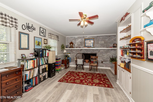 home office featuring plenty of natural light, crown molding, light hardwood / wood-style flooring, and a brick fireplace