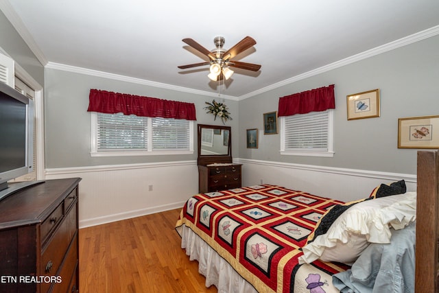 bedroom with ceiling fan, light wood-type flooring, and crown molding