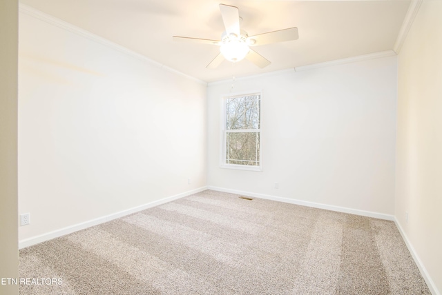 carpeted spare room with ceiling fan and ornamental molding