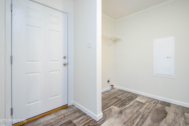 laundry area featuring wood-type flooring, electric panel, ornamental molding, and hookup for an electric dryer