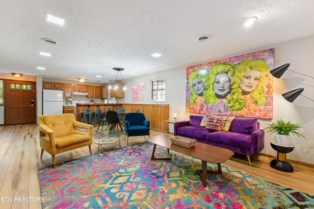 living room featuring light hardwood / wood-style floors and a textured ceiling