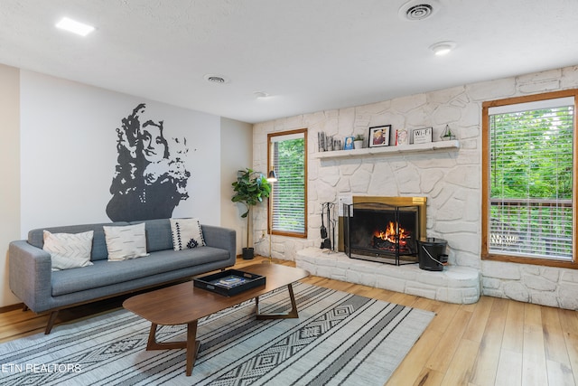 living room featuring hardwood / wood-style flooring and a stone fireplace