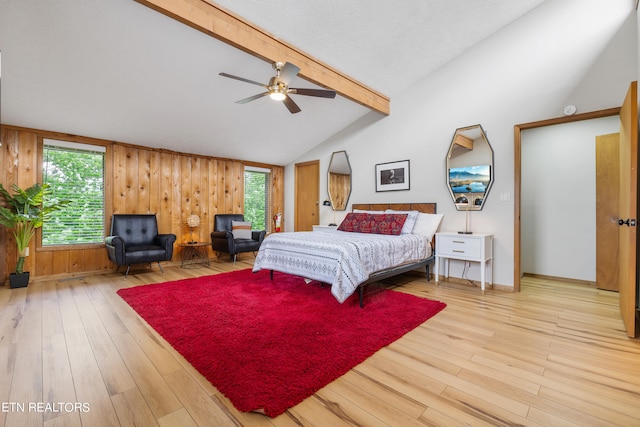 bedroom featuring hardwood / wood-style floors, vaulted ceiling with beams, ceiling fan, and wooden walls