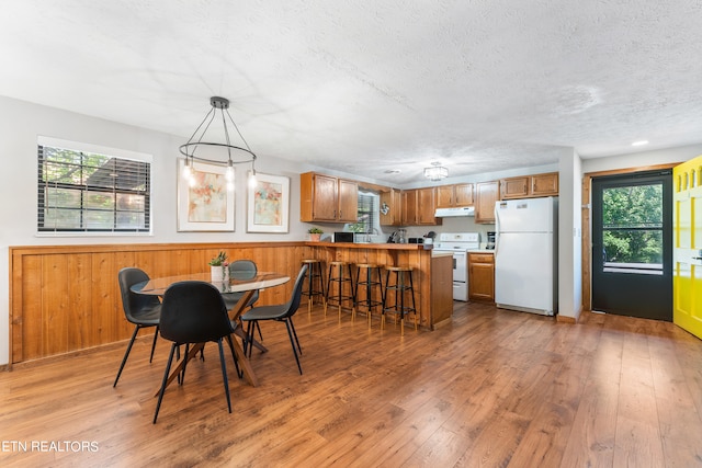 dining area featuring a textured ceiling and light hardwood / wood-style floors