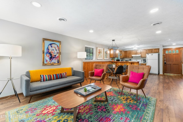 living room featuring a textured ceiling and hardwood / wood-style flooring