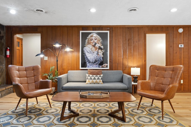 living room featuring wood-type flooring and wood walls