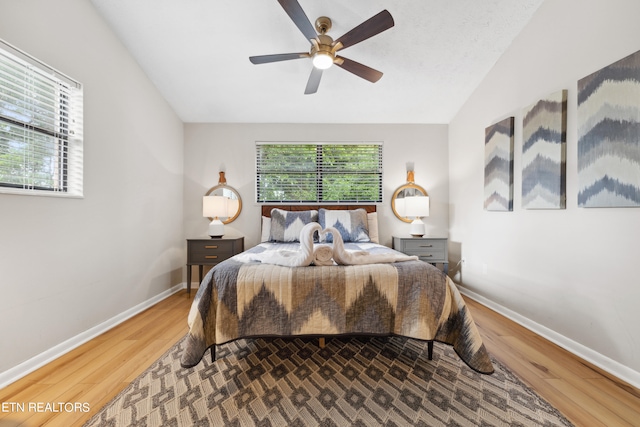 bedroom with hardwood / wood-style flooring, ceiling fan, and lofted ceiling