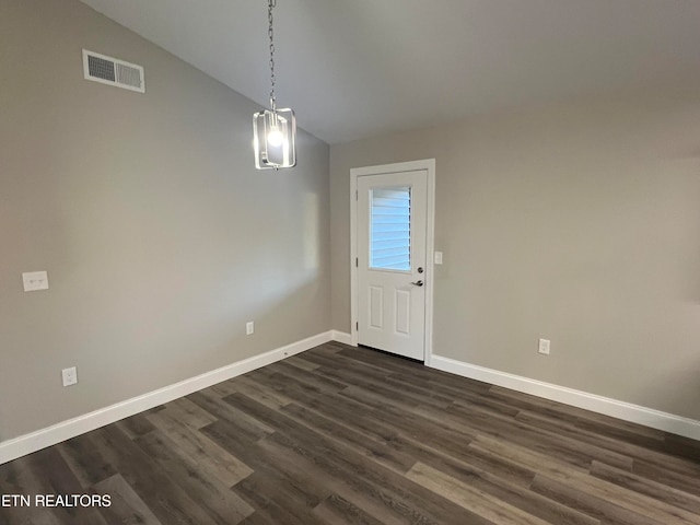 unfurnished dining area with lofted ceiling, dark wood-type flooring, and a chandelier