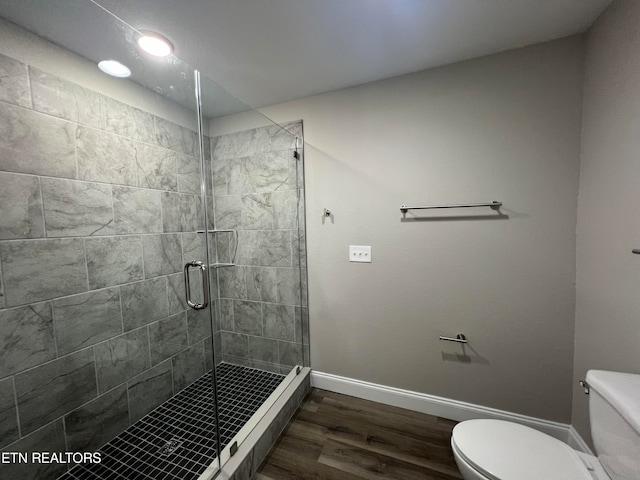 bathroom with hardwood / wood-style flooring, toilet, and an enclosed shower