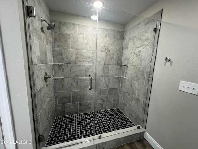 bathroom featuring a shower with door and hardwood / wood-style floors