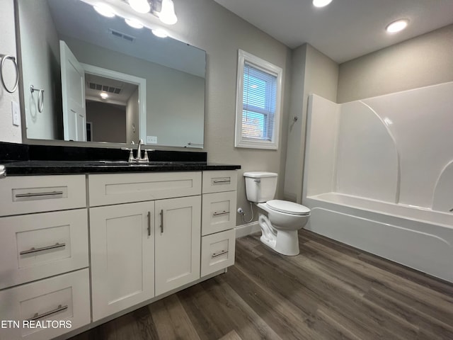 full bathroom featuring bathtub / shower combination, vanity, wood-type flooring, and toilet