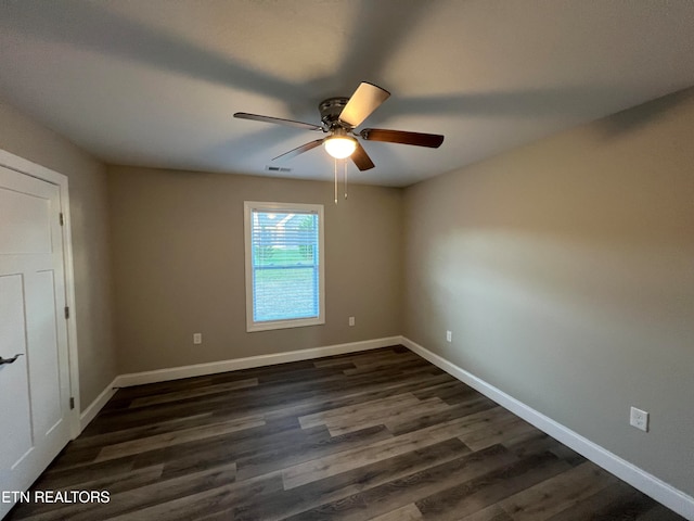 empty room with ceiling fan and dark hardwood / wood-style flooring